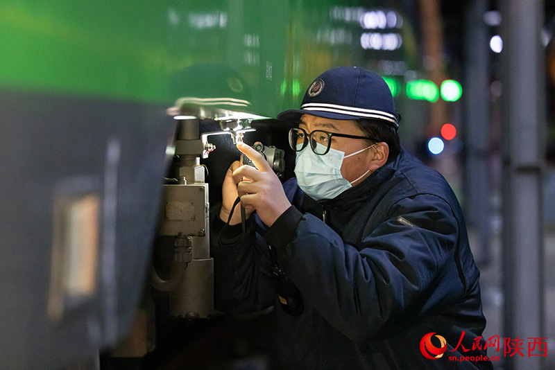 1月26日，西安客車車輛段，鐵路檢修“小哥”正在檢查動(dòng)力集中型動(dòng)車組注水口保證旅客正常用水。劉翔攝