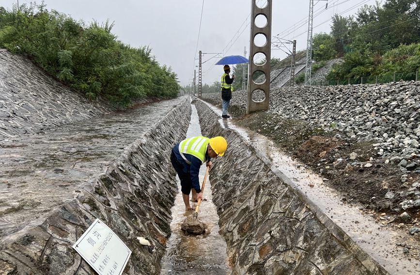 漢中工務段西鄉(xiāng)線路車間防洪人員在陽安線西鄉(xiāng)至沙河坎區(qū)間清理水溝。金嶸攝