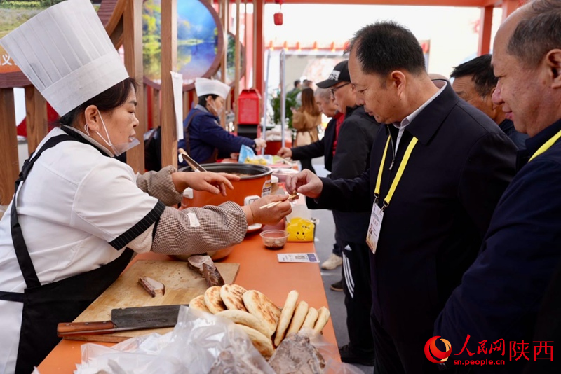 參展觀眾在渭南展館品嘗特色美食。人民網(wǎng)記者 鄒星攝