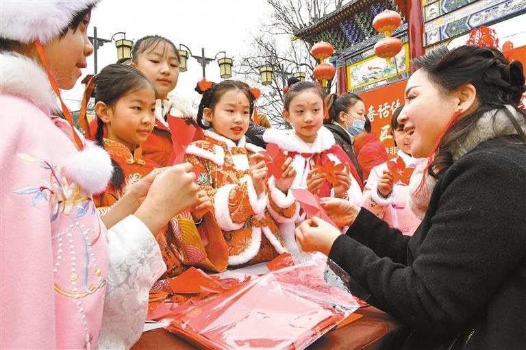 1月20日，西安永興坊·陜西非遺文化特色街區(qū)內(nèi)，非遺傳承人給孩子們教授剪紙、捏面人等非遺技藝。杜瑋攝