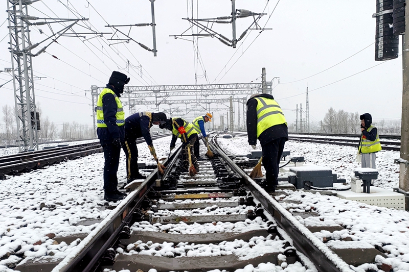 西安鐵路局綏德工電段神木西綜合維修車間職工正在進(jìn)行掃雪除冰作業(yè)。劉盼利  攝