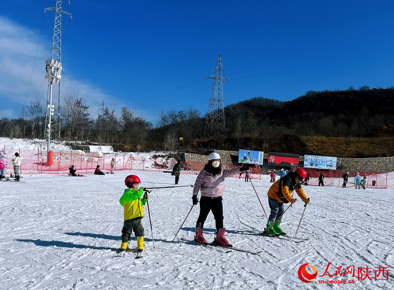 雪友們?cè)诨﹫?chǎng)滑雪，盡情體驗(yàn)滑雪運(yùn)動(dòng)帶來的快樂。人民網(wǎng)記者 魏鑫攝